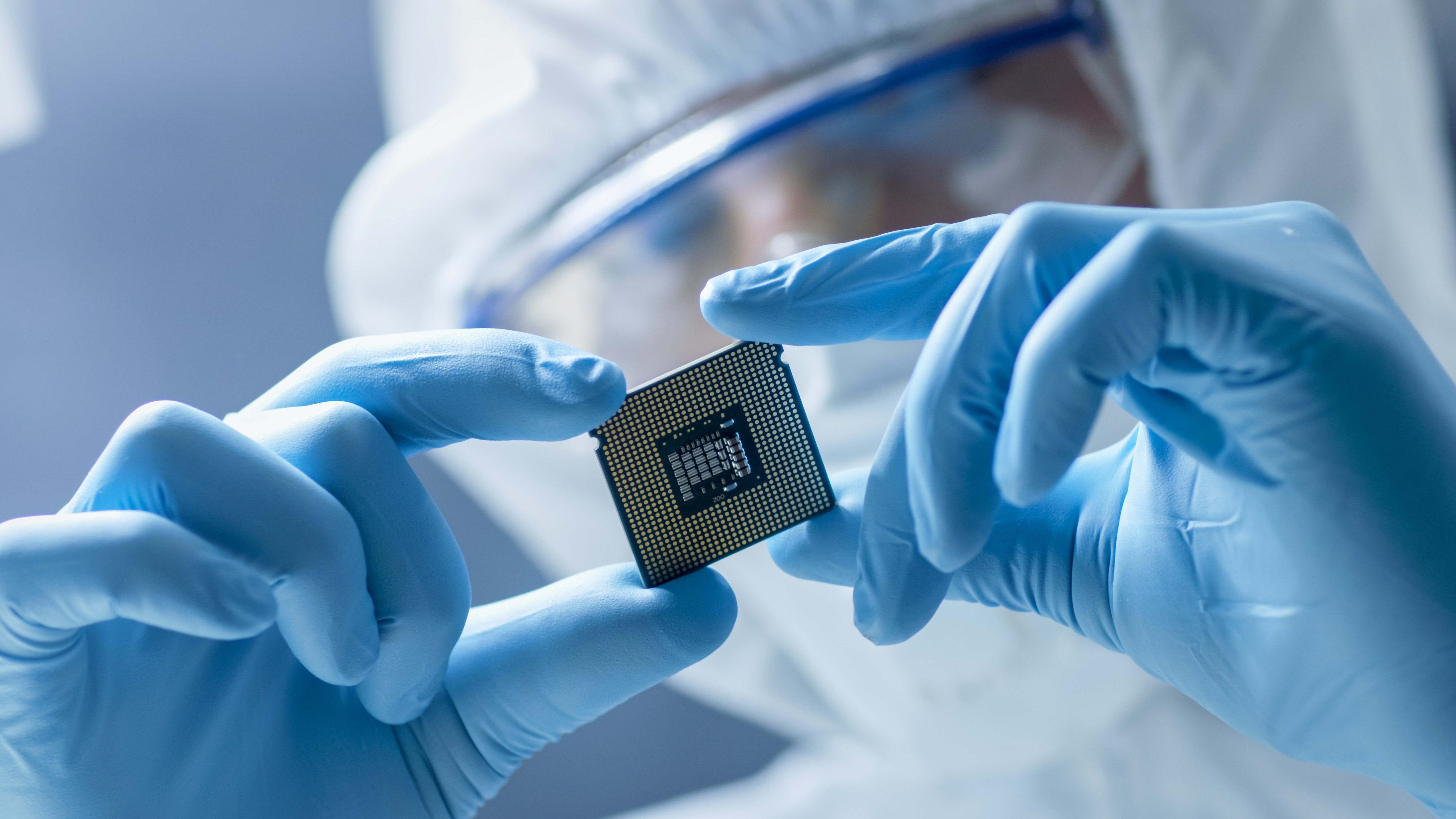 semiconductor cleanroom worker examining microchip