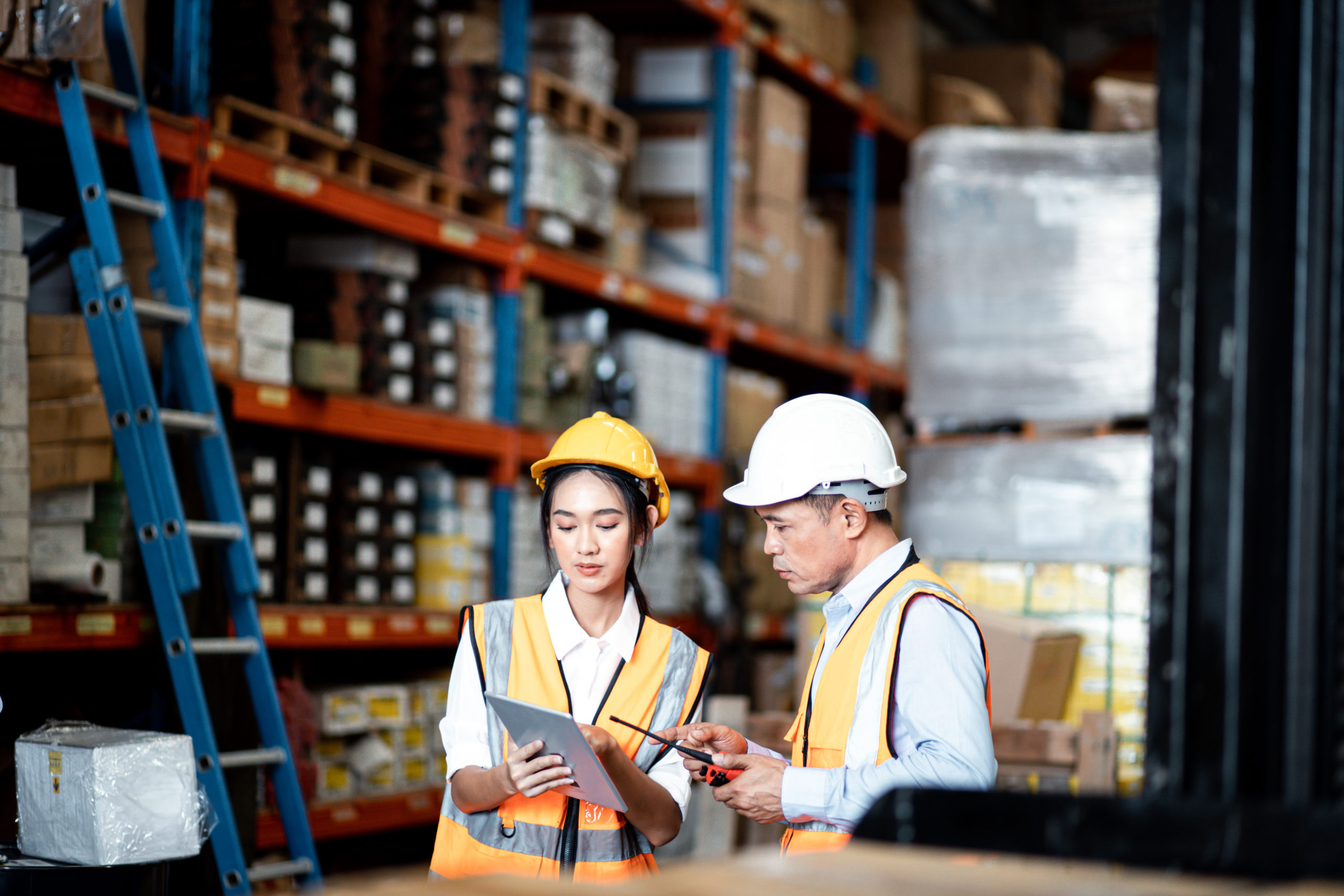 warehouse workers looking at their inventory & warehouse management software solution on a tablet